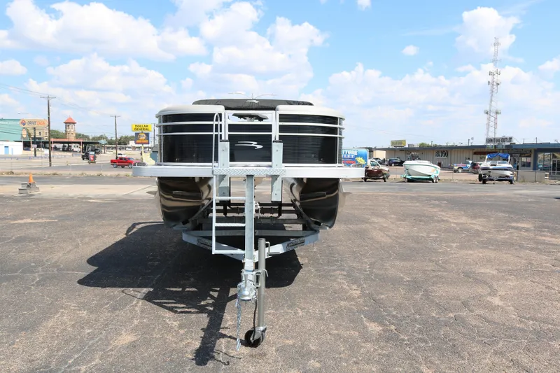 Slide: The Image of 2026 Bennington 20SSRCX STERN RADIUS pontoon boat on trailer in parking lot. - 2