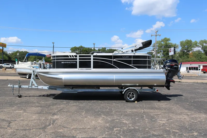 Slide: The Image of 2026 Bennington 20SSRCX STERN RADIUS pontoon boat on trailer, parked outdoors. - 4