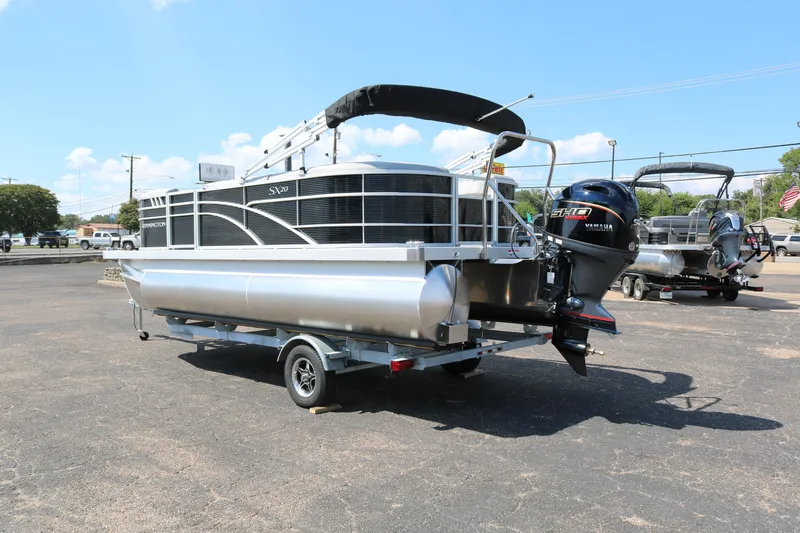 Slide: The Image of 2026 Bennington 20SSRCX pontoon boat with Yamaha engine on trailer, parked outdoors. - 5