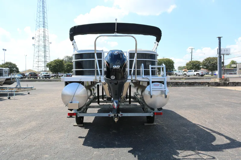 Slide: The Image of 2026 Bennington 20SSRCX pontoon boat with 90 HP engine, parked outdoors. - 6