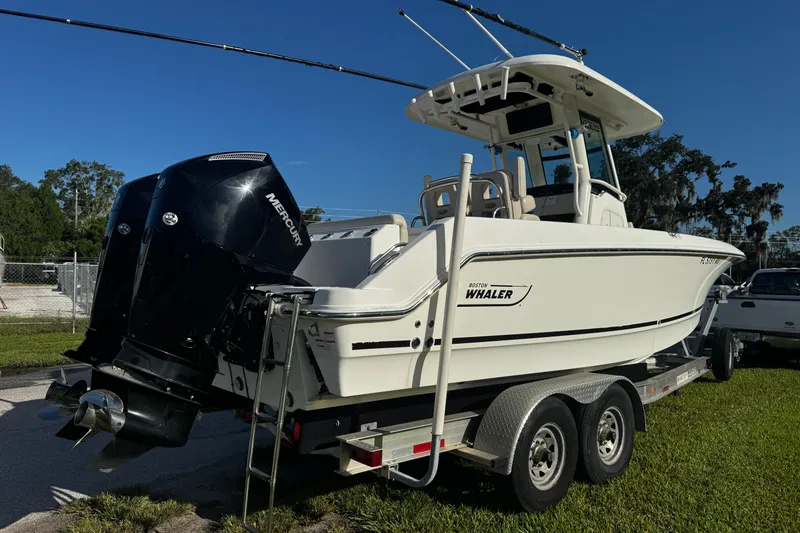 The Image of 2019 Boston Whaler 26 Outrage boat on trailer, featuring dual Mercury engines. - 1