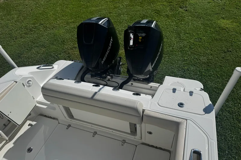 Slide: The Image of 2019 Boston Whaler 26 Outrage boat with dual Mercury outboard engines, on grassy background. - 17