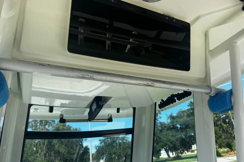 Slide: The Image of Interior view of a 2019 Boston Whaler 26 Outrage boat, featuring a metal rod and overhead compartment. - 8