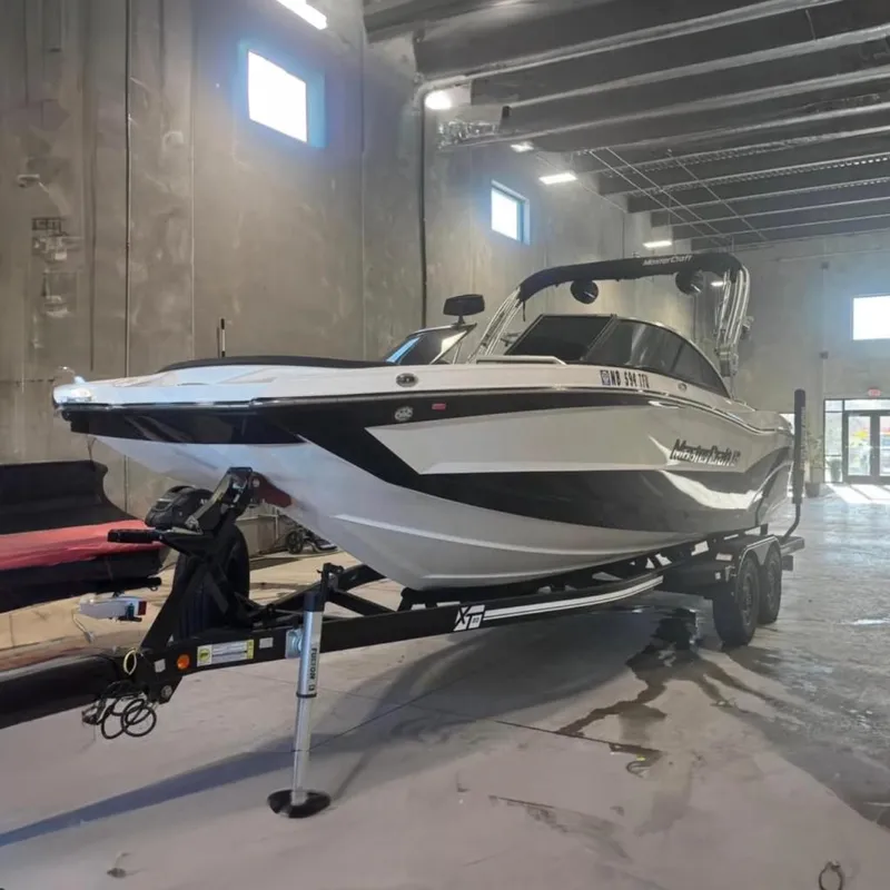 Slide: The Image of 2019 MasterCraft XT22 boat on trailer in a warehouse setting. - 0