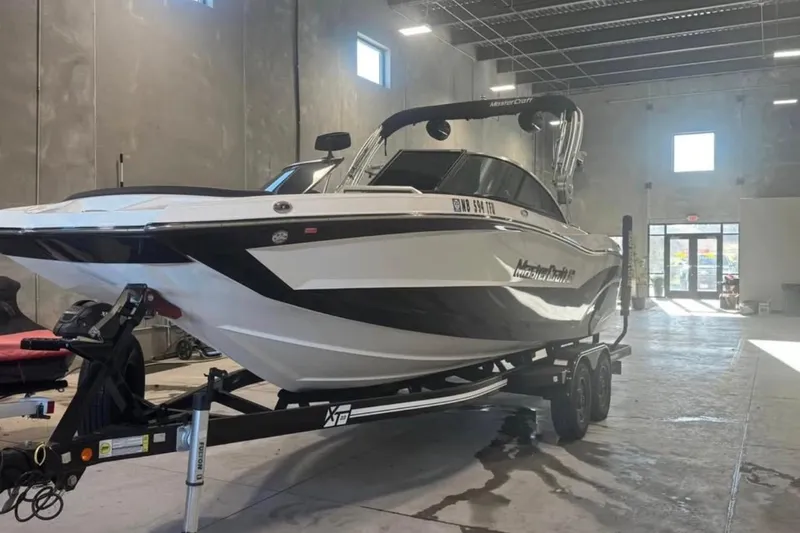 Slide: The Image of 2019 MasterCraft XT22 boat on trailer in a warehouse setting. - 1