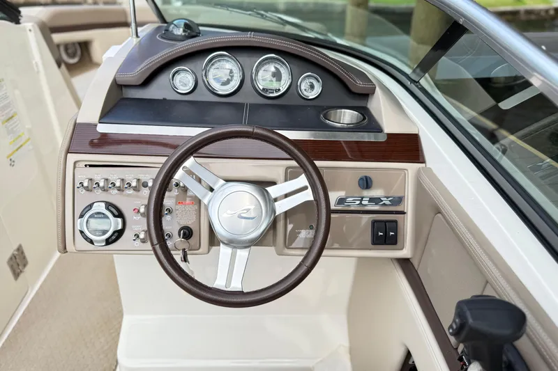 Slide: The Image of 2013 Sea Ray 250 SLX boat dashboard with steering wheel and control panel. - 14