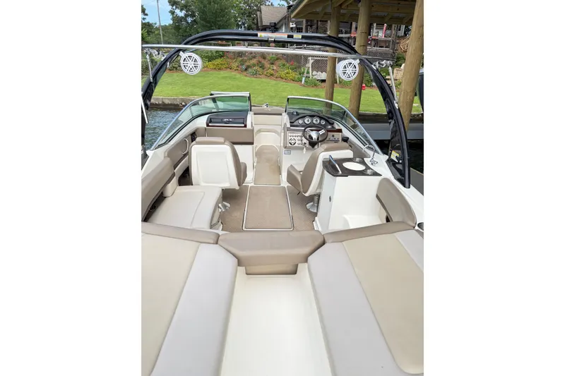 Slide: The Image of 2013 Sea Ray 250 SLX boat interior with beige seating and modern dashboard. - 15