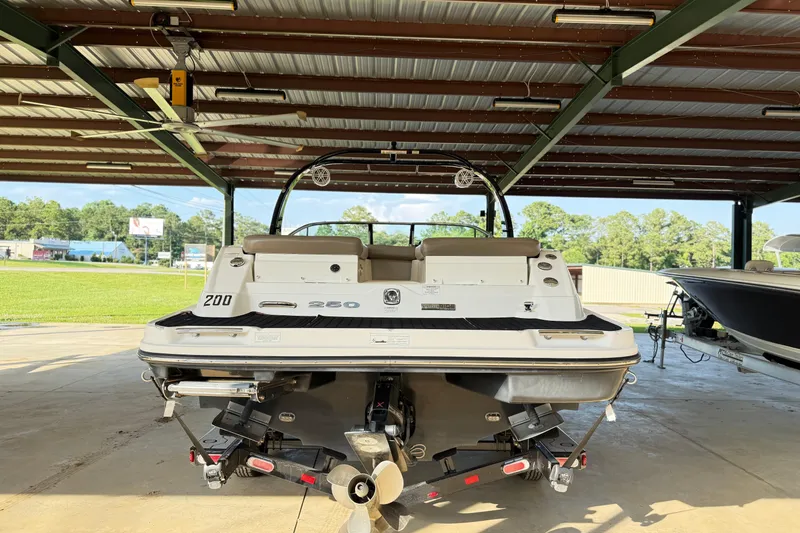 Slide: The Image of 2013 Sea Ray 250 SLX boat on trailer under a metal canopy. - 7