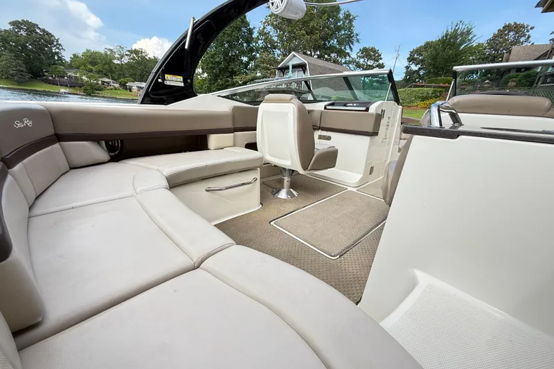 Slide: The Image of 2013 Sea Ray 250 SLX boat interior with beige seating and lake view. - 9