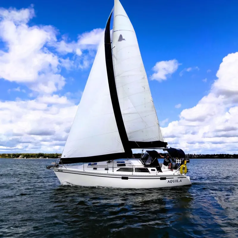 Slide: The Image of Sailboat "Aquila" on water, 1992 Hunter 33.5 model, under clear blue sky. - 0