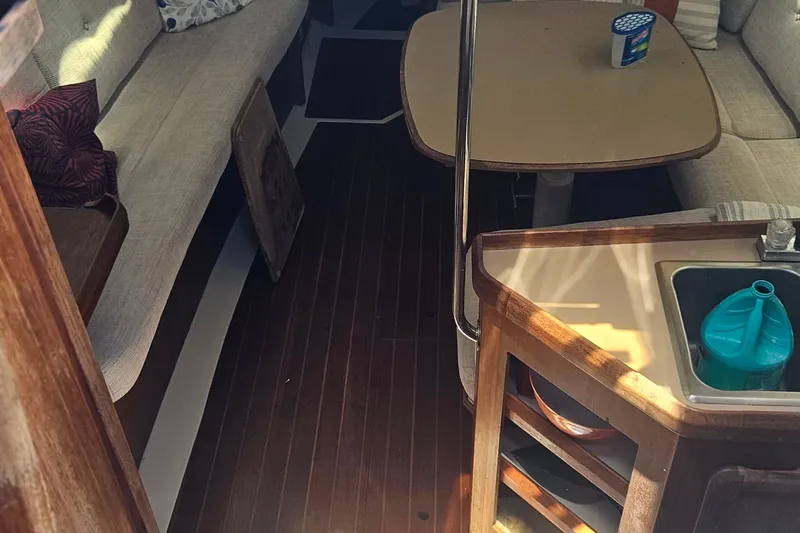 Slide: The Image of Interior of a 1991 Hunter 34 sailboat with seating, table, and kitchenette. - 11
