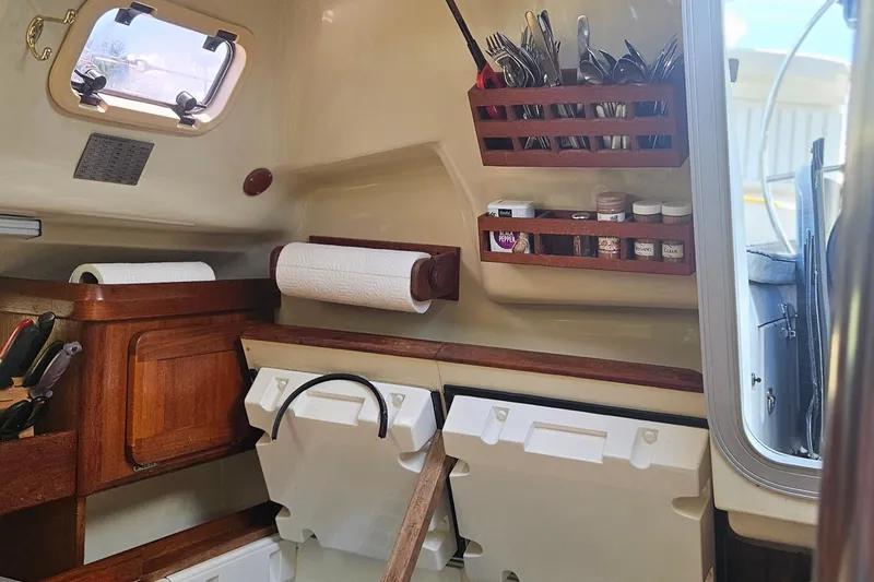 Slide: The Image of Interior of a 1991 Hunter 34 sailboat galley with organized storage and utensils. - 12
