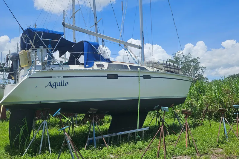 Slide: The Image of Hunter 34 sailboat from 1991 named "Aquila" on stands, set against a clear blue sky. - 21