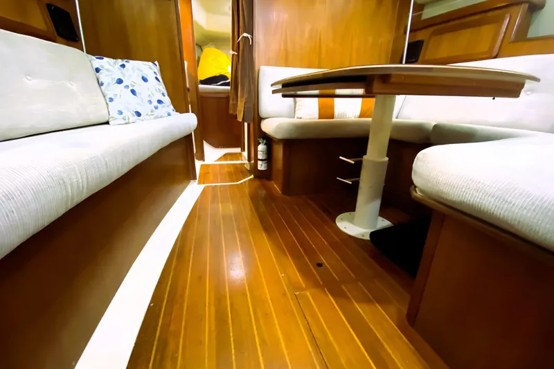 Slide: The Image of Interior of a 1992 Hunter 33.5 sailboat with wooden flooring and cozy seating area. - 8