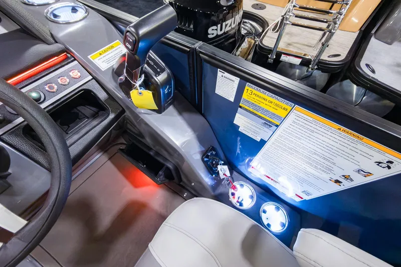 Slide: The Image of Interior of 2026 Godfrey Monaco 235 boat, featuring controls and safety labels. - 12