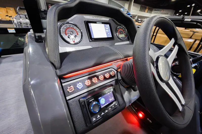 Slide: The Image of 2026 Godfrey Monaco 235 boat dashboard with steering wheel and control panel. - 13