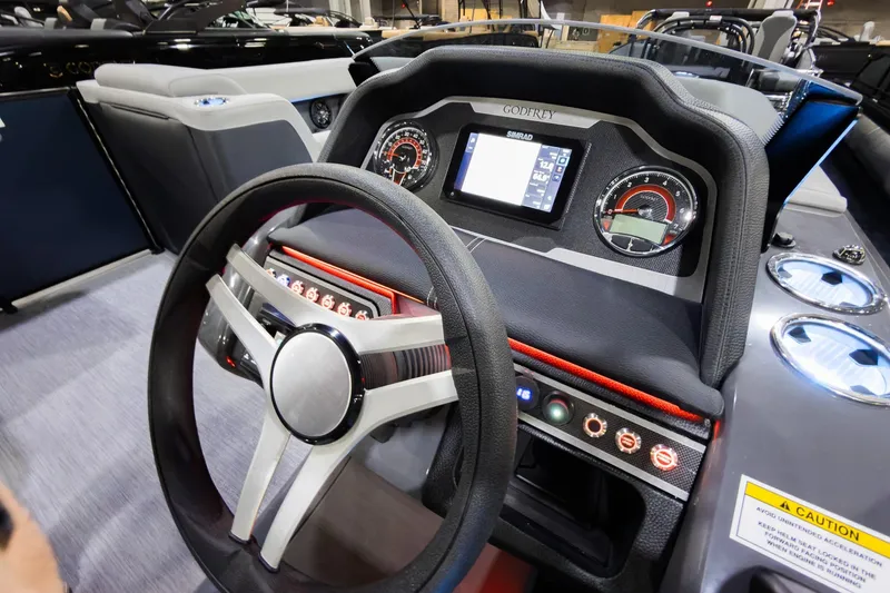 Slide: The Image of 2026 Godfrey Monaco 235 boat dashboard with steering wheel and digital display. - 14