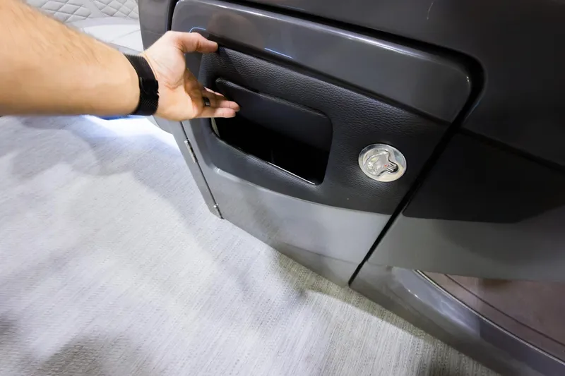 Slide: The Image of Hand opening storage compartment on 2026 Godfrey Monaco 235 Single Flip Lounge boat. - 9