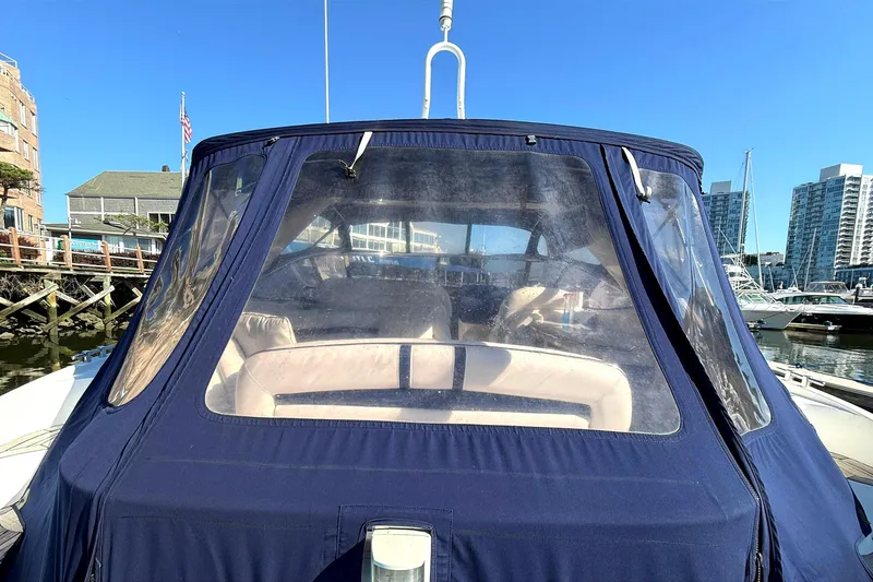 Slide: The Image of 2002 Sunseeker Camargue 44 yacht with blue canopy docked in marina. - 16