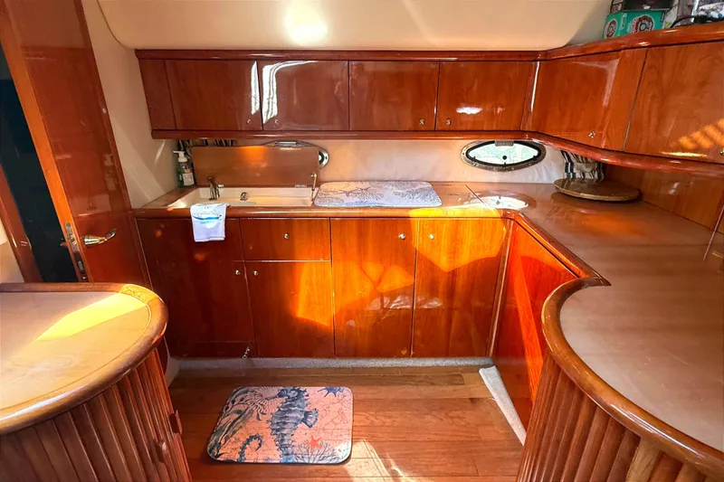 Slide: The Image of Luxurious wooden kitchen interior of 2002 Sunseeker Camargue 44 yacht, featuring elegant cabinetry. - 6