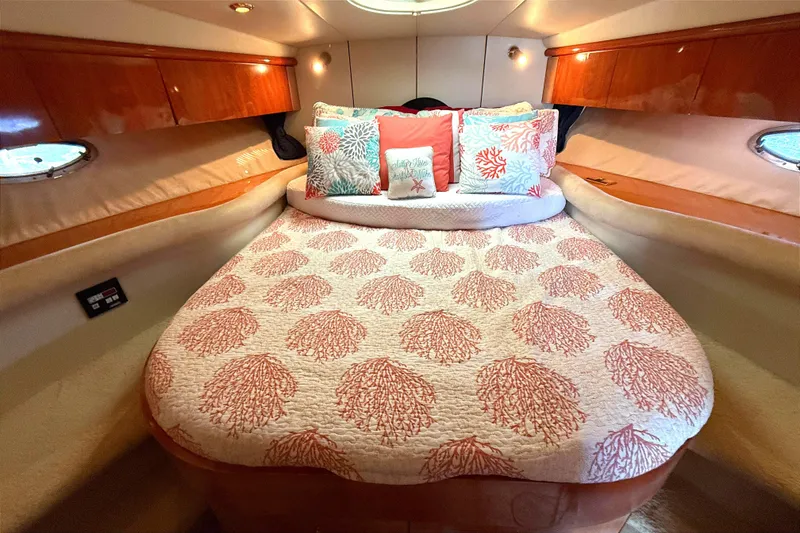 Slide: The Image of Luxurious 2002 Sunseeker Camargue 44 cabin with coral-themed bedding and elegant wood accents. - 9