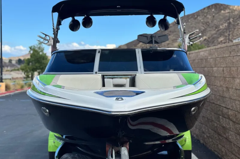 Slide: The Image of 2014 Centurion Enzo SV244 boat with green accents, parked outdoors. - 3