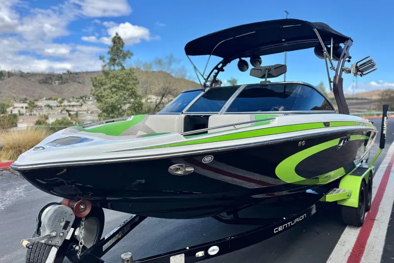 Slide: The Image of 2014 Centurion Enzo SV244 boat with green accents on a trailer, scenic background. - 4