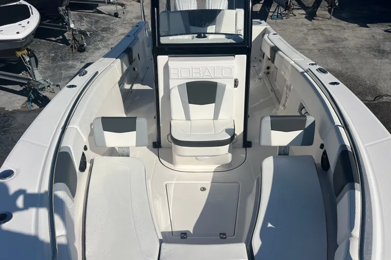 Slide: The Image of 2025 Robalo R270 Center Console boat interior with seating and console, docked outdoors. - 12