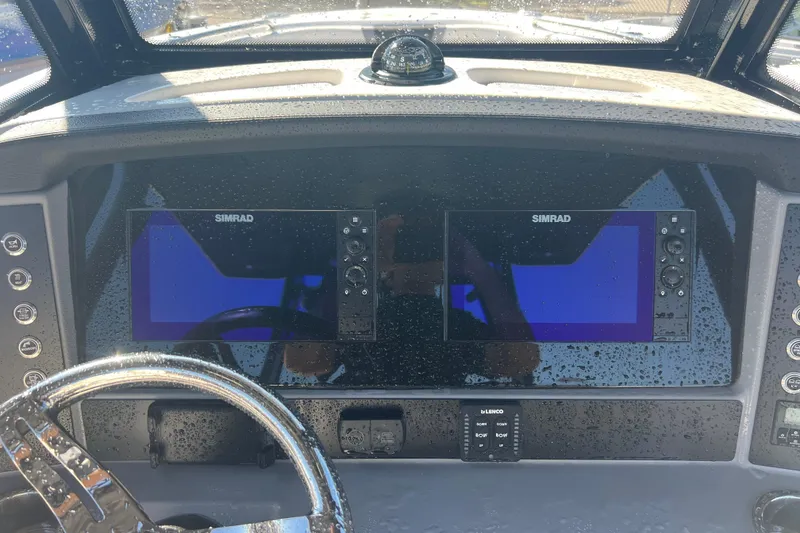 Slide: The Image of 2025 Robalo R270 Center Console dashboard with dual Simrad displays and steering wheel. - 9