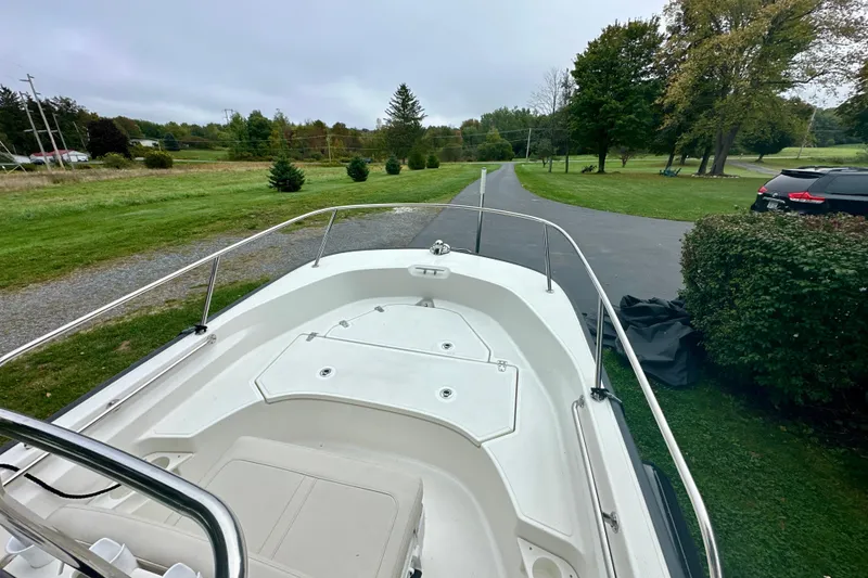 Slide: The Image of 2024 Boston Whaler 170 Montauk boat on a driveway, surrounded by greenery. - 10