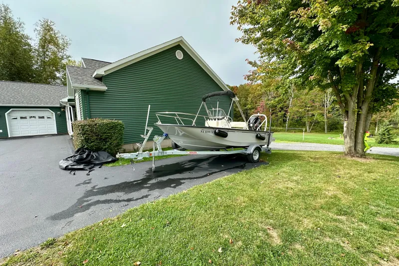 Slide: The Image of 2024 Boston Whaler 170 Montauk boat on trailer beside green house. - 3