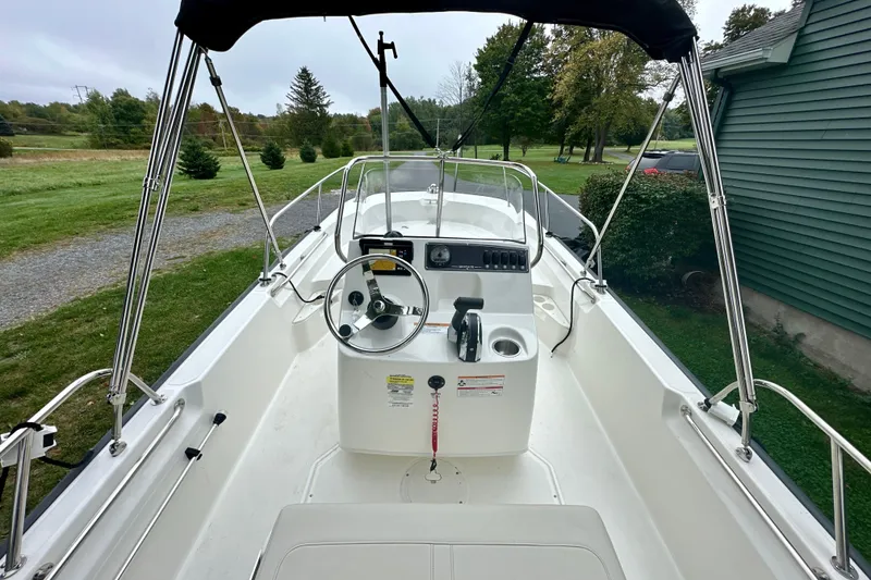 Slide: The Image of 2024 Boston Whaler 170 Montauk boat interior with steering console and canopy. - 9