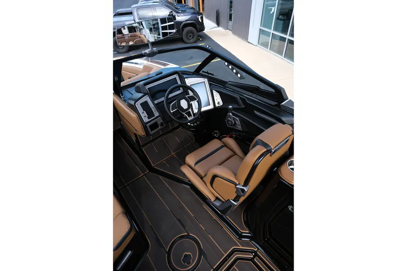 Slide: The Image of 2023 Supra SE550 boat interior with luxurious brown seating and modern dashboard design. - 12