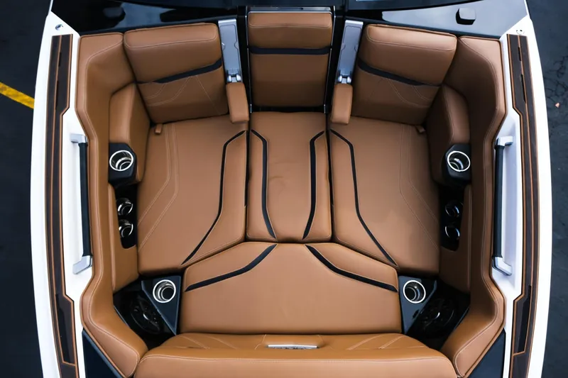 Slide: The Image of 2023 Supra SE550 boat interior with luxurious brown leather seating and cup holders. - 19