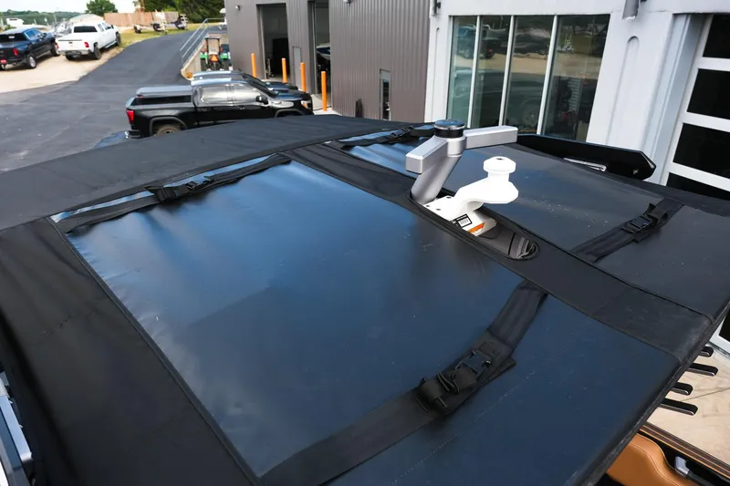 Slide: The Image of 2023 Supra SE550 boat with black canvas cover and mounted equipment. - 29