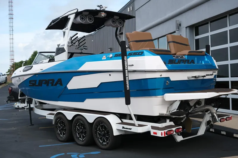 Slide: The Image of 2023 Supra SE550 boat with blue and white design, parked on a trailer. - 5