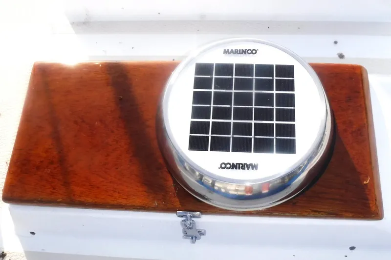 Slide: The Image of Solar-powered vent on 1989 Tartan 37 boat, featuring Marinco branding and wooden base. - 10