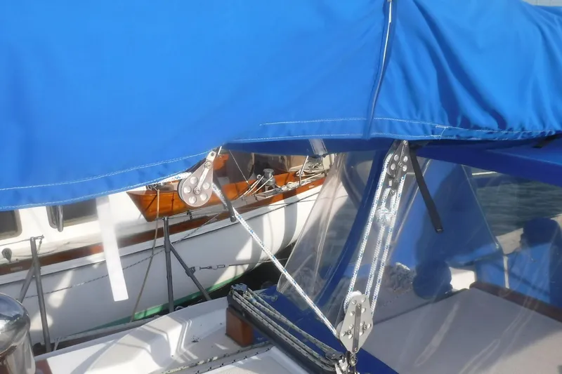 Slide: The Image of 1989 Tartan 37 sailboat with blue canopy and rigging details. - 12