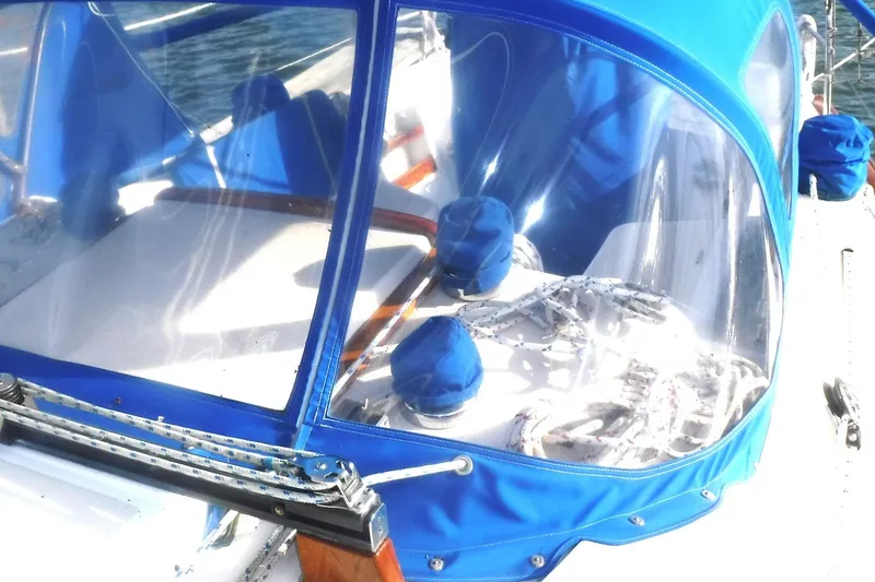 Slide: The Image of 1989 Tartan 37 sailboat cockpit with blue canvas cover and clear windows. - 13