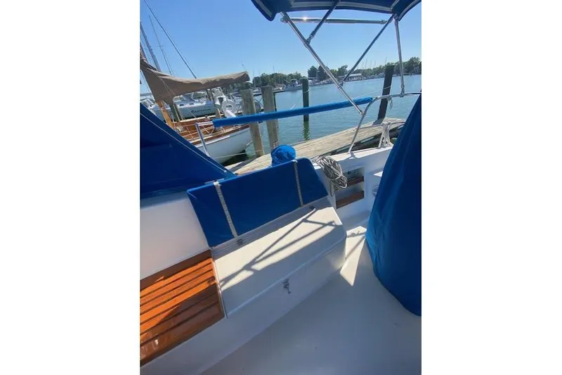 Slide: The Image of 1989 Tartan 37 sailboat docked, featuring blue canvas and wooden accents. - 28