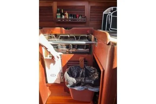 Slide: The Image of 1989 Tartan 37 yacht kitchen with stove, storage, and trash bin. - 36