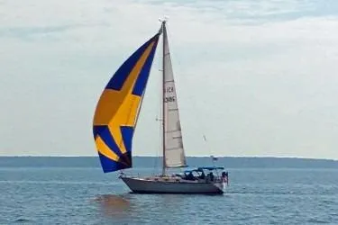 Slide: The Image of 1989 Tartan 37 sailboat with colorful spinnaker on open water. - 4