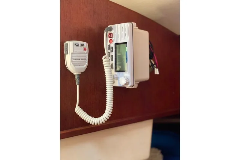 Slide: The Image of VHF marine radio mounted on a wooden panel inside a 1989 Tartan 37 sailboat. - 44