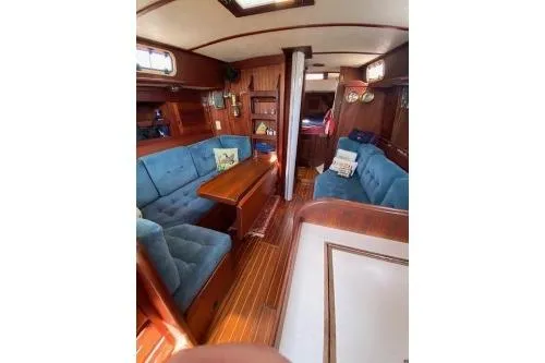 Slide: The Image of 1989 Tartan 37 sailboat interior with blue seating and wooden finishes. - 46