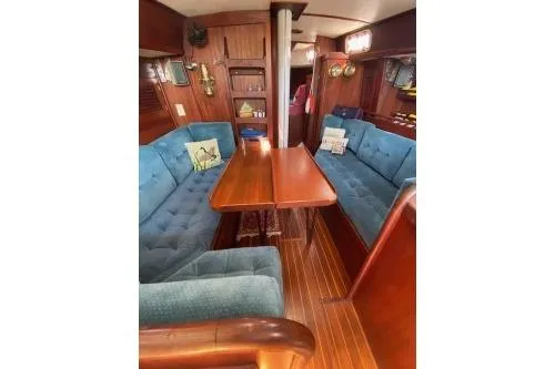 Slide: The Image of 1989 Tartan 37 sailboat interior with blue seating, wooden table, and nautical decor. - 48