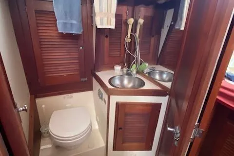 Slide: The Image of 1989 Tartan 37 yacht bathroom with wooden cabinets and stainless steel sink. - 53