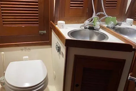 Slide: The Image of 1989 Tartan 37 yacht bathroom with wooden cabinets and stainless steel sink. - 54