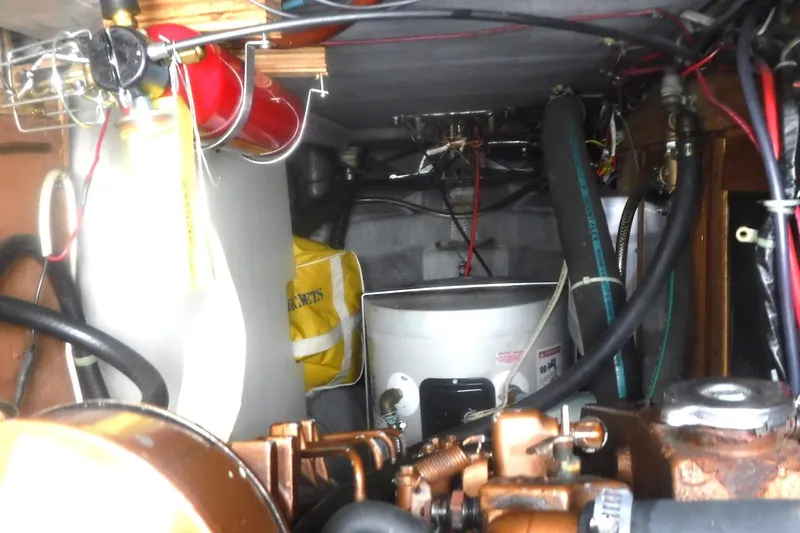Slide: The Image of Engine compartment of a 1989 Tartan 37 sailboat, featuring various mechanical components and wiring. - 58