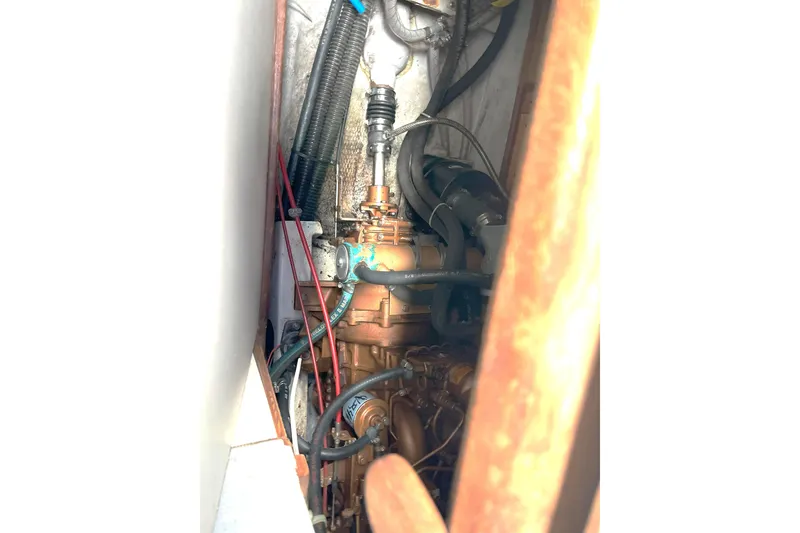 Slide: The Image of Engine compartment of a 1989 Tartan 37 sailboat, showcasing mechanical components and wiring. - 60