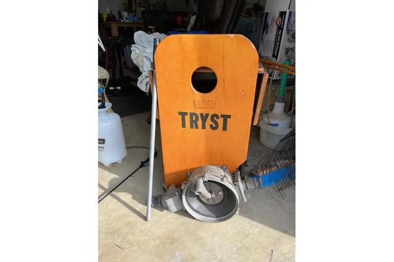 Slide: The Image of Wooden boat part labeled "Tryst" from a 1989 Tartan 37, in a garage setting. - 63